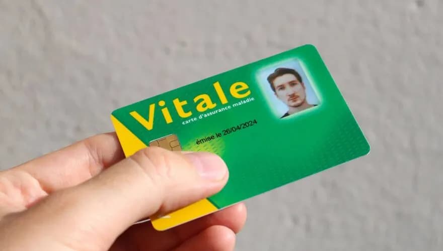 Hand holding a French Carte Vitale health-insurance card
